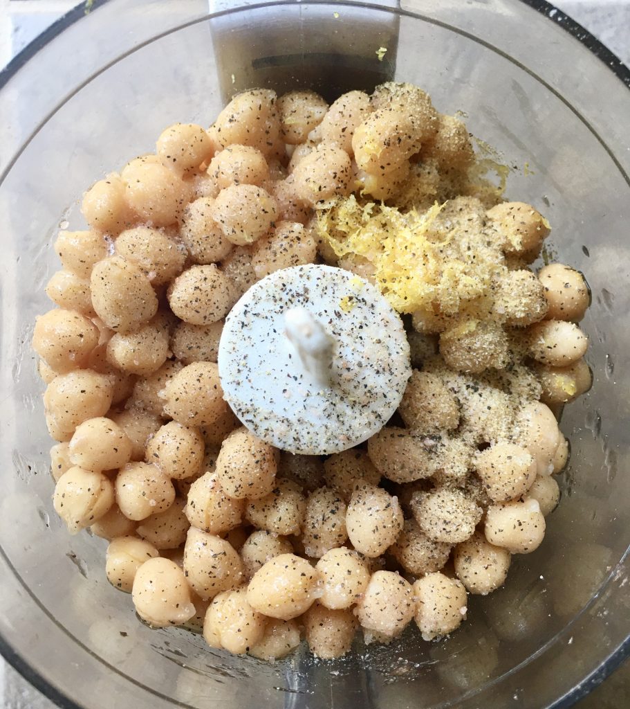 mini food processor filled with canned chickpeas and seasonings