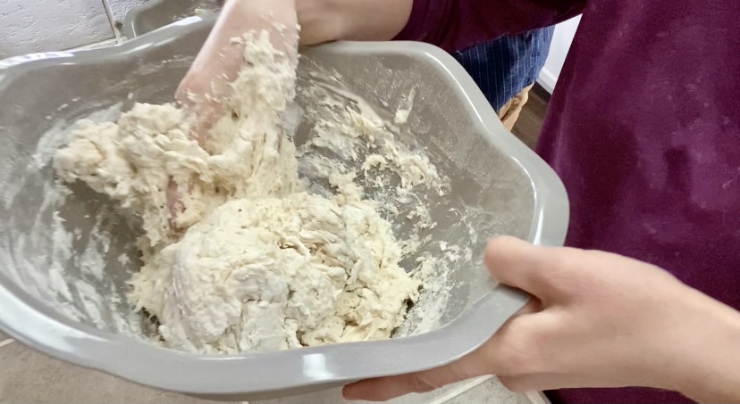 mixing sourdough dough in a large bowl